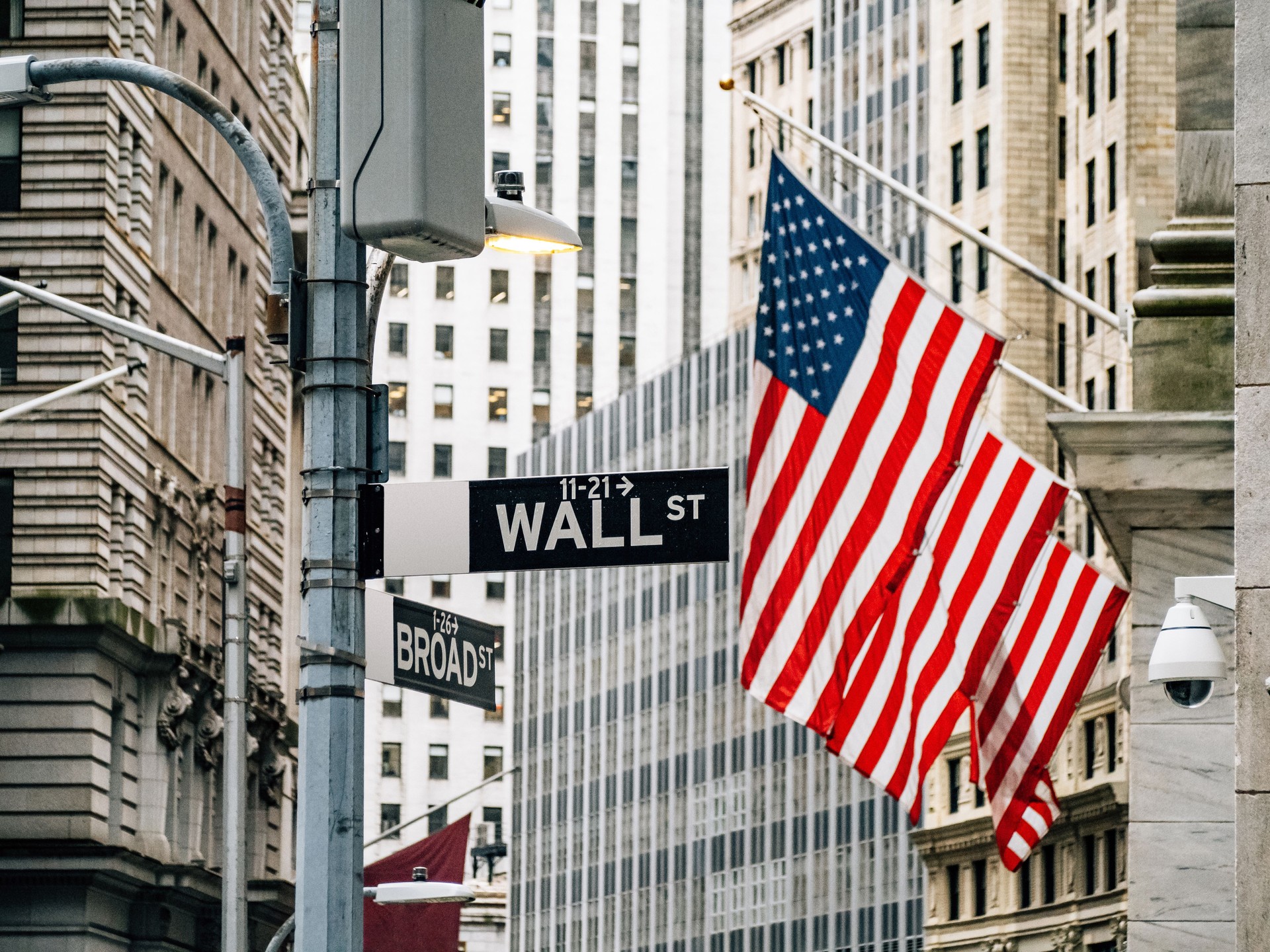 Wall street district in New York City with USA flags in the background