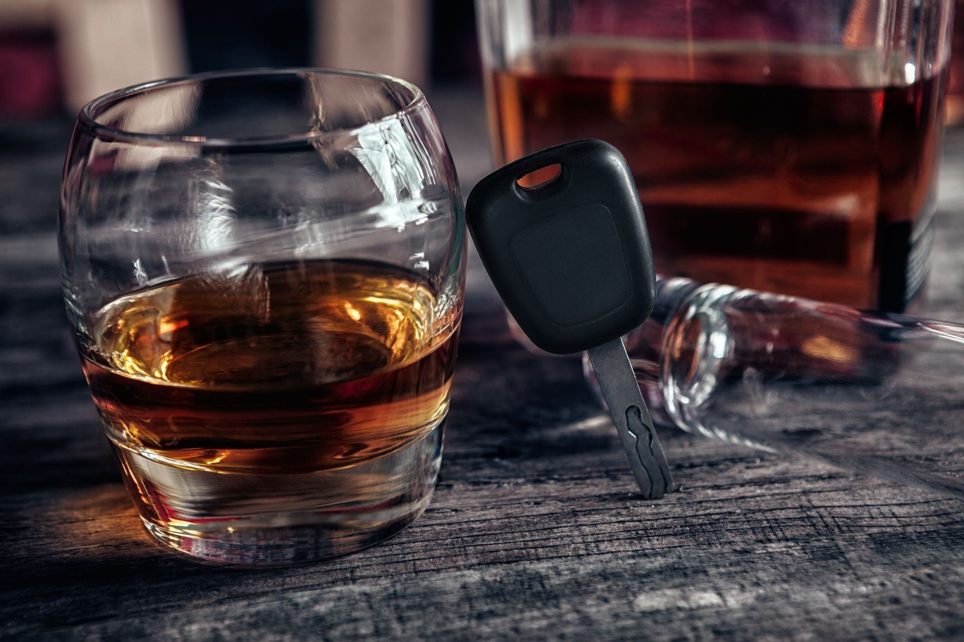 Alcohol drink,car keys and empty glass on bar table
